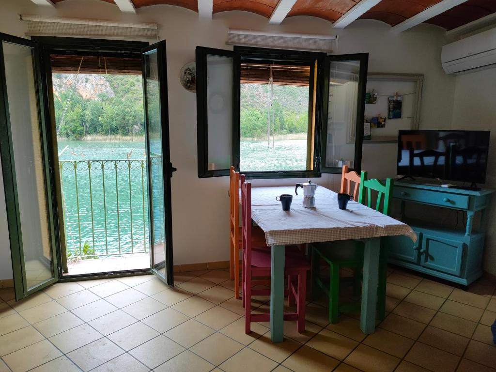 a dining room with a table and a view of the water at Lo Raconet in Sant Llorenç de Montgai