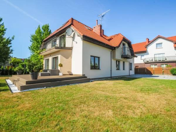 a large white house with a grass yard at Willa u Tośka in Kołobrzeg