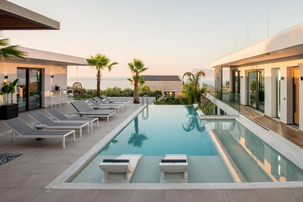 uma piscina com espreguiçadeiras e um hotel em Villa Lydia I Superb views, two pools, next to the city em Kissamos