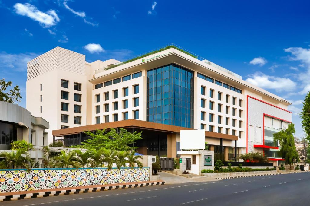 a building on a street with a road at Lemon Tree Premier, Vijayawada in Vijayawāda