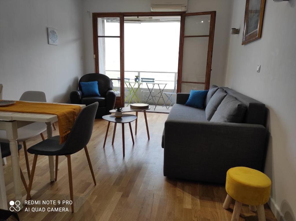 uma sala de estar com um sofá, uma mesa e cadeiras em Appartement vacances Marseille em Marselha