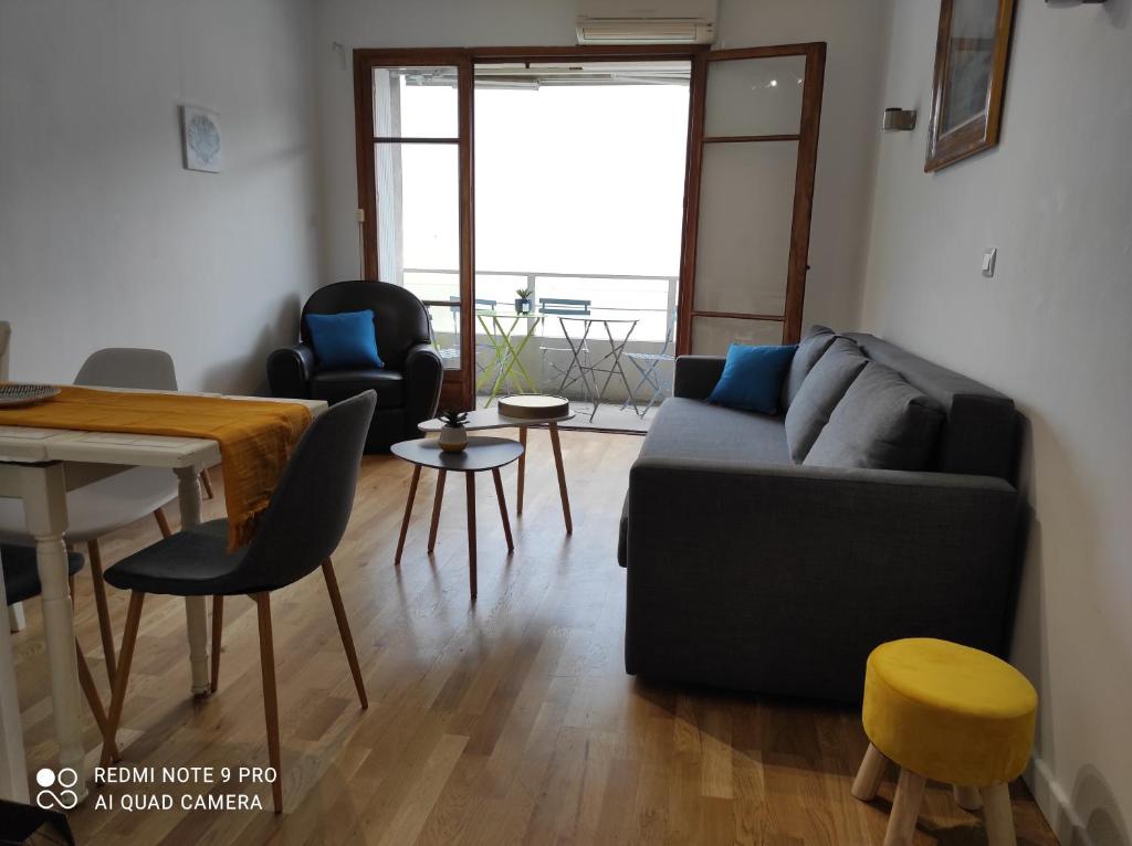 un salon avec un canapé, une table et des chaises dans l'établissement Appartement vacances Marseille, à Marseille