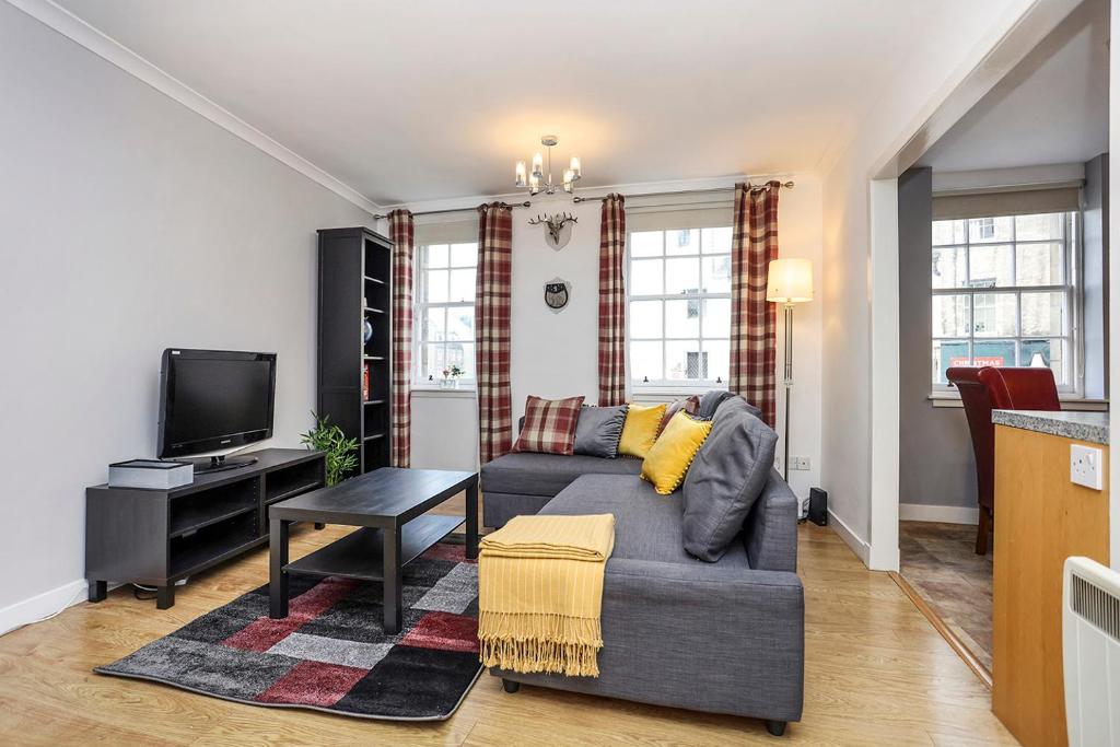 - un salon avec un canapé et une télévision dans l'établissement JOIVY Cosy 1 bed flat next to Grassmarket and Royal Mile, à Édimbourg