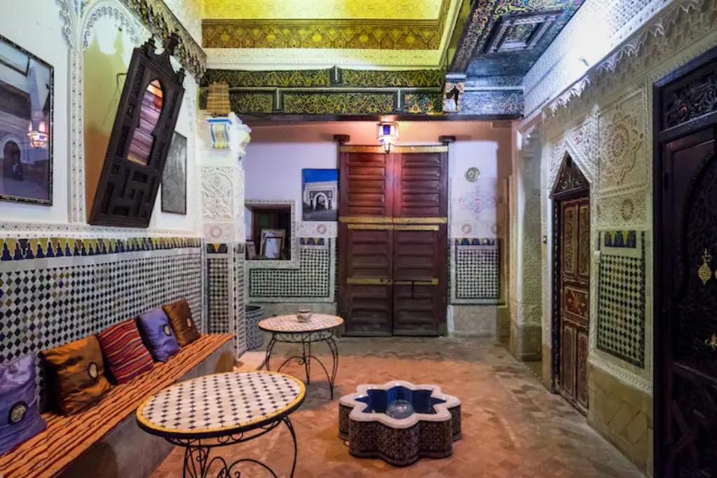 a living room with two tables and a couch at Riad Malak in Fez