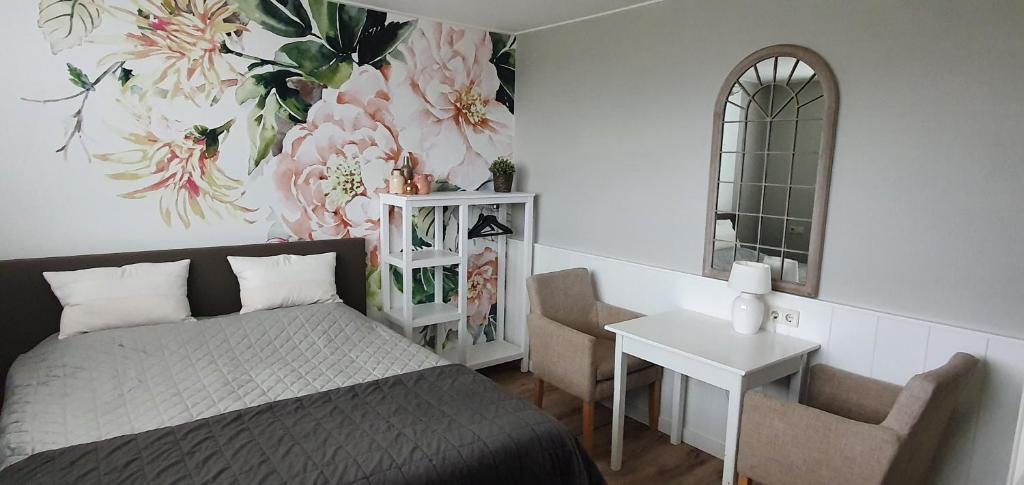 - une chambre avec un lit, une table et un miroir dans l'établissement B&B Duinroos De Koog - Texel, à De Koog