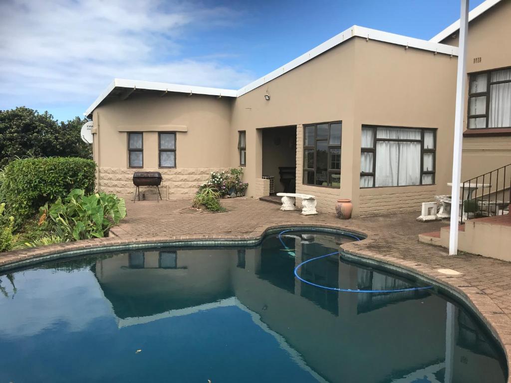 una casa con piscina delante de una casa en Oceanic, en Scottburgh