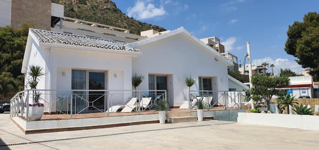 Casa blanca con balcón con sillas en Sandra Rooms en Alicante