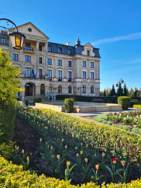 un edificio con un jardín delante de él en Pałac Bursztynowy, en Włocławek