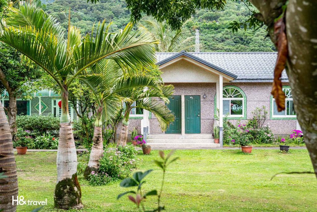a house with palm trees in front of it at Shan Tyi Homestay in Ji&#39;an