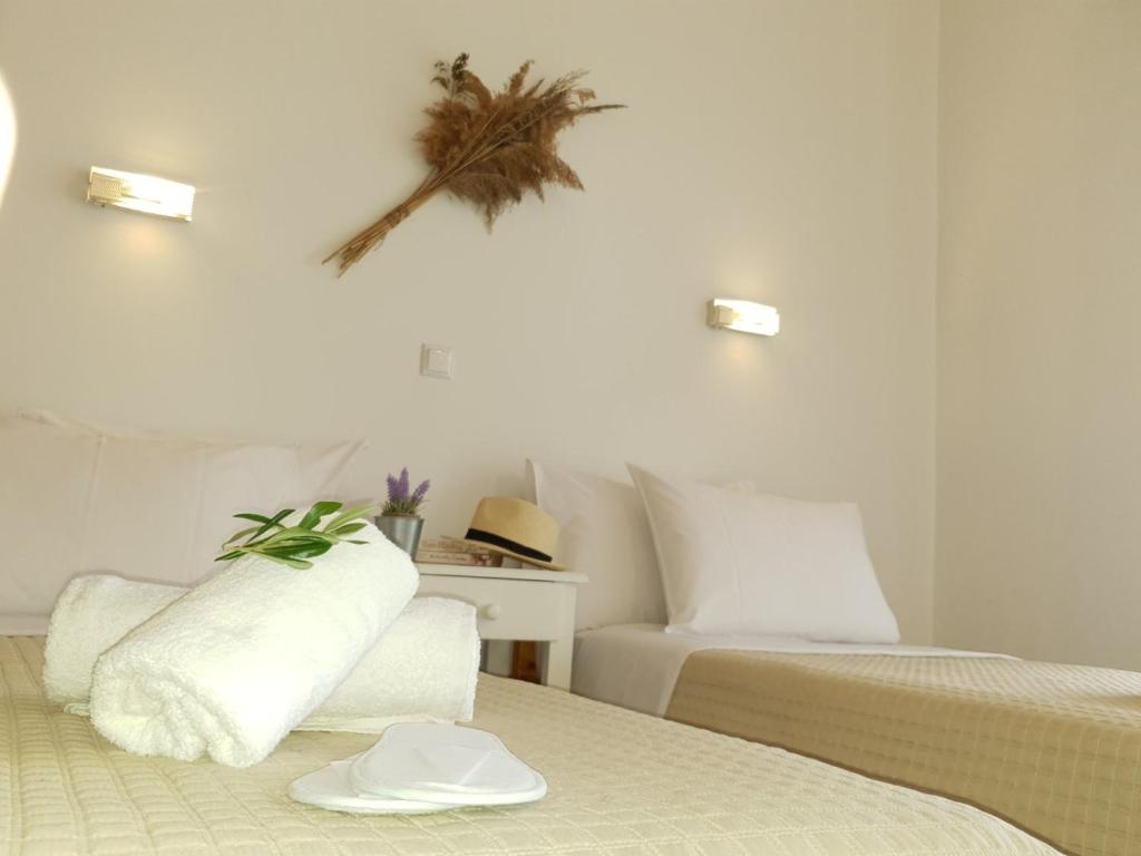 a hotel room with two beds and a hat on the wall at Corfu Olivia Apartments in Moraitika