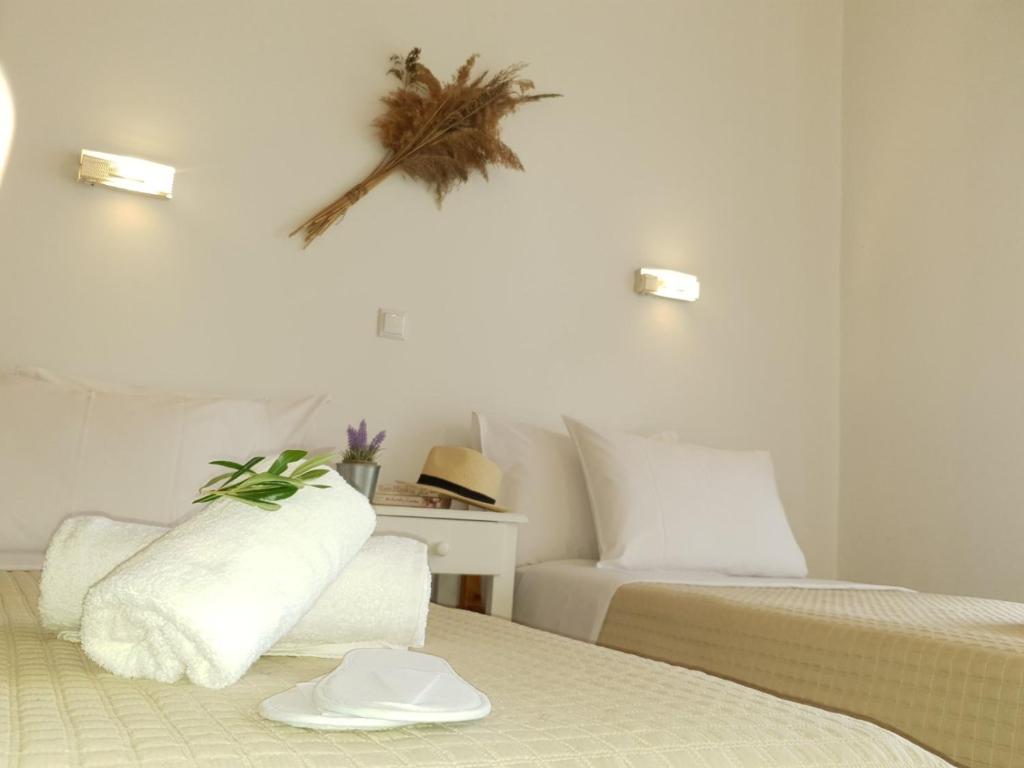 ein Hotelzimmer mit 2 Betten und einem Hut an der Wand in der Unterkunft Corfu Olivia Apartments in Moraḯtika