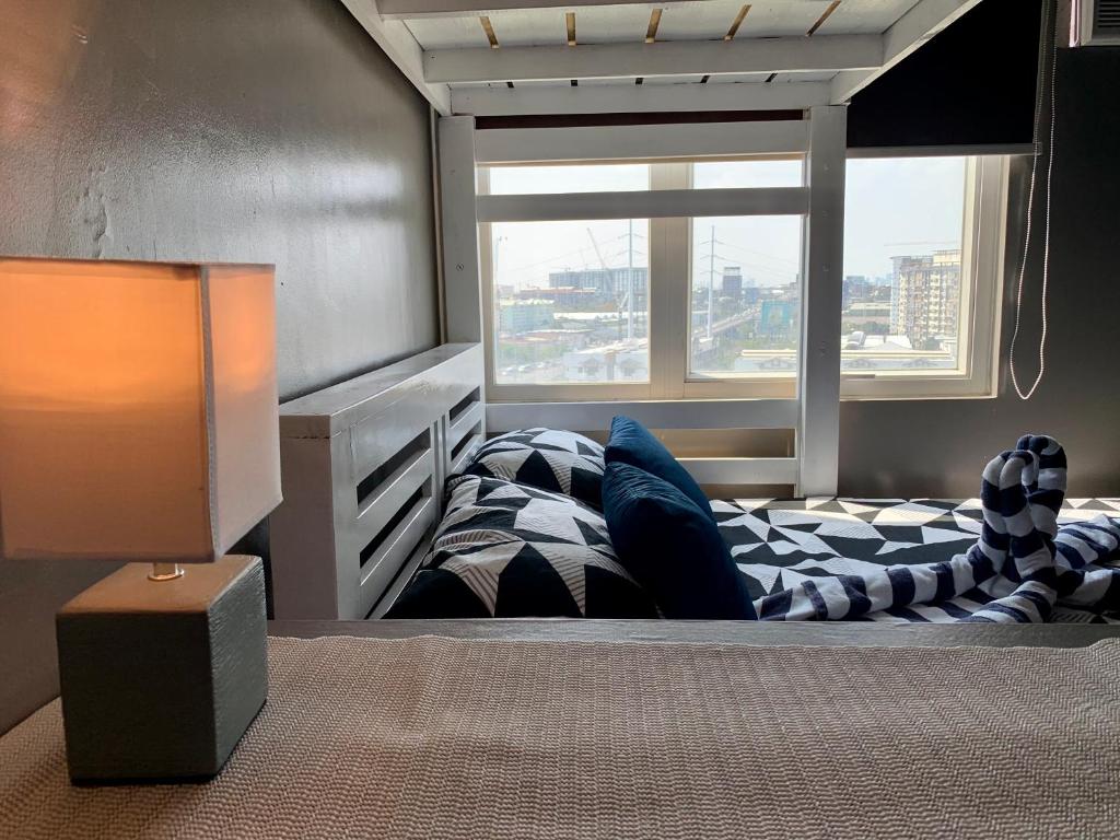 a bedroom with a bed and a window at Anuva Condominium with Netflix in Manila