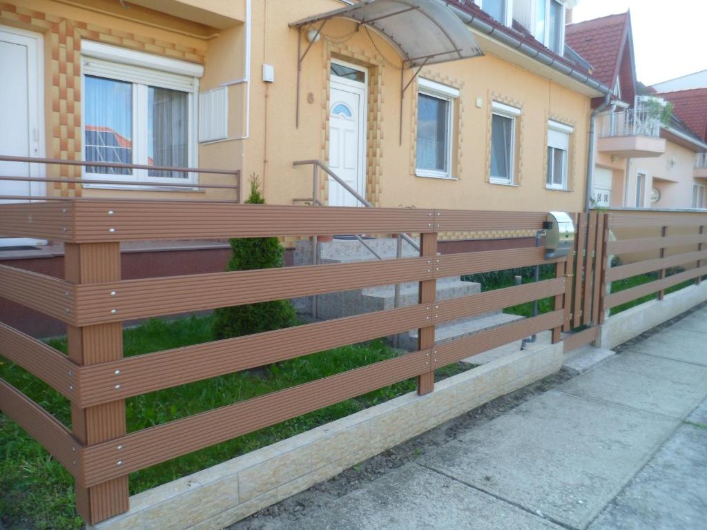 a wooden fence in front of a house at Makai Apartman in Hajdúszoboszló