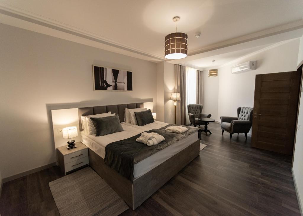 een slaapkamer met een bed, een bureau en een stoel bij Downtown Suites Yerevan in Jerevan