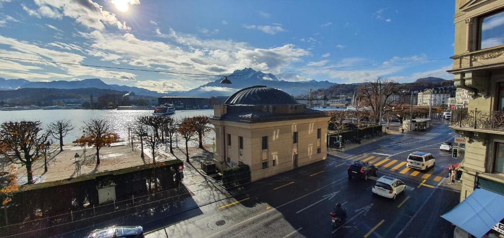 a building with a dome on top of it next to a street at Belle Epoque Luzern in Lucerne