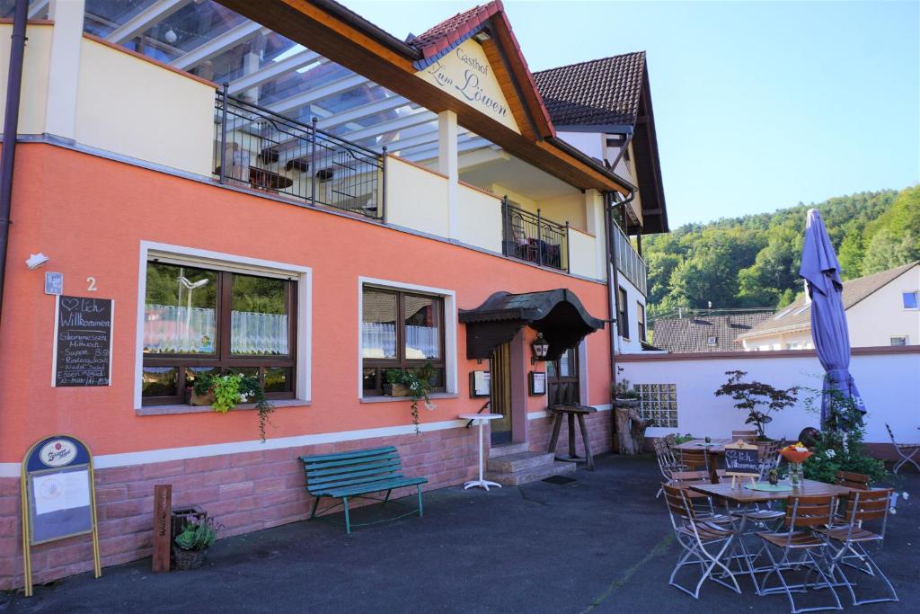 ein Gebäude mit einem Tisch und Stühlen davor in der Unterkunft Gasthof Zum Löwen in Mespelbrunn