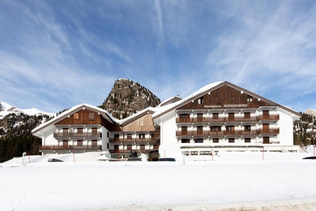 a hotel in the snow in front of a mountain at Casa Dolomiti in Moena