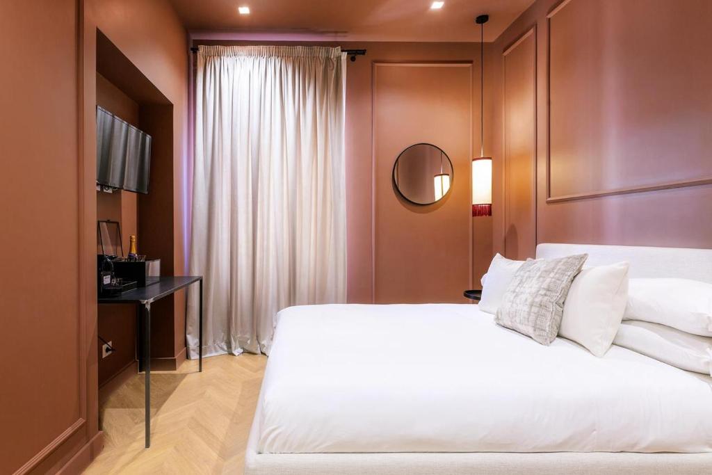 una camera da letto con un grande letto bianco e uno specchio di The Couper Colonna a Roma