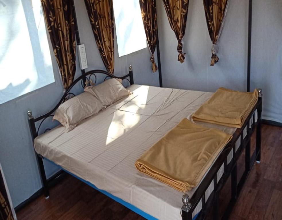 ein großes Bett in einem Zimmer mit Fenster in der Unterkunft Jungle retreat dandeli - Homestay in Joida