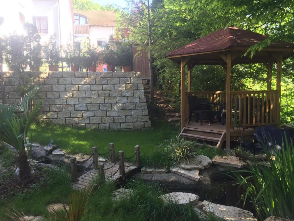 a garden with a gazebo and a pond at Tübingen Denzenberg / MIT GARTEN / FREE Parking in Tübingen