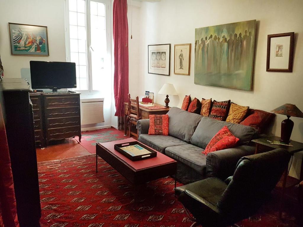ein Wohnzimmer mit einem Sofa und einem TV in der Unterkunft Family Apartment Old Town near Beach AC in Nizza