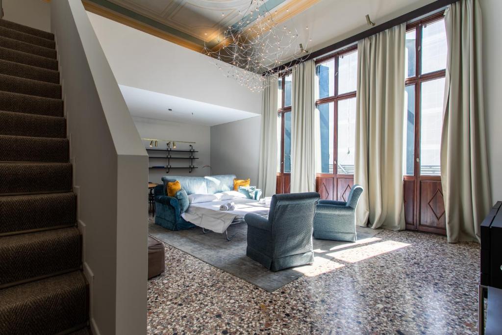 een woonkamer met een bank en 2 stoelen bij Infinite House Ca' Vendramin in Venetië