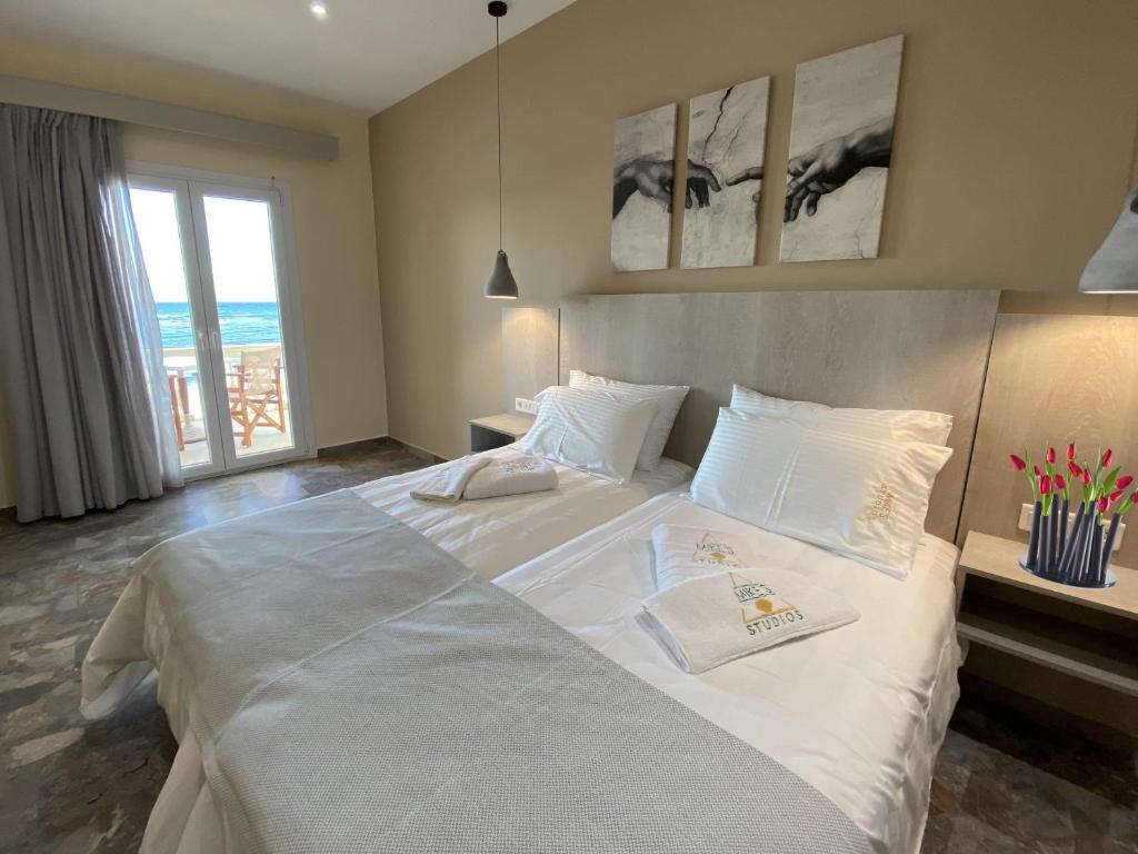 a large white bed in a bedroom with a window at MIKE'S STUDIOS in Sidari