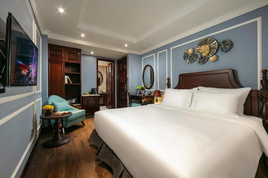 Postel nebo postele na pokoji v ubytování Romantique Hotel De Hanoi