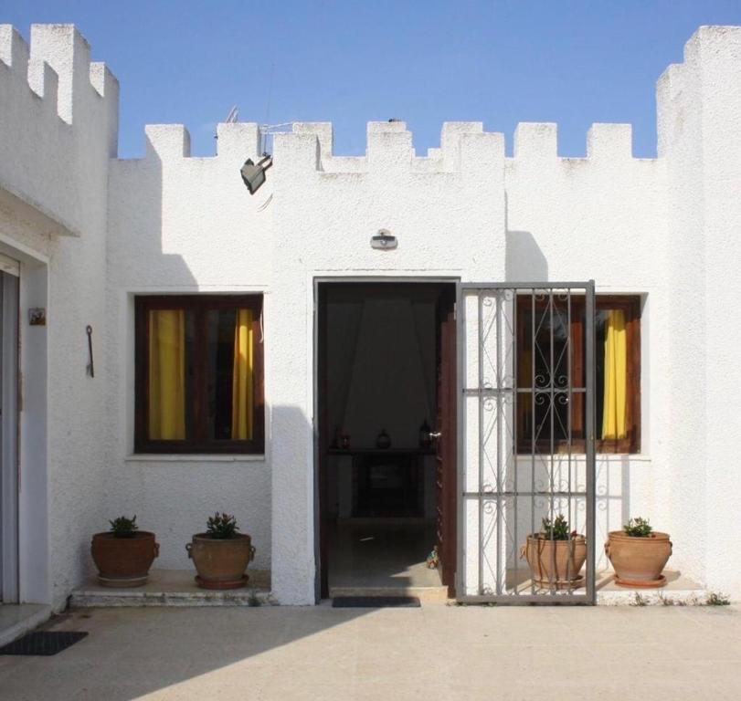 a white building with a door and some plants at Casa El Castellet en Polop. in Polop
