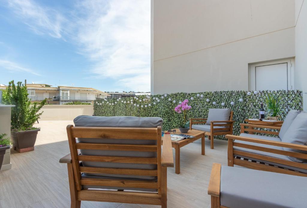 un patio con sillas, mesas y una valla en M A R I V E N T Private Terrace en Rosas