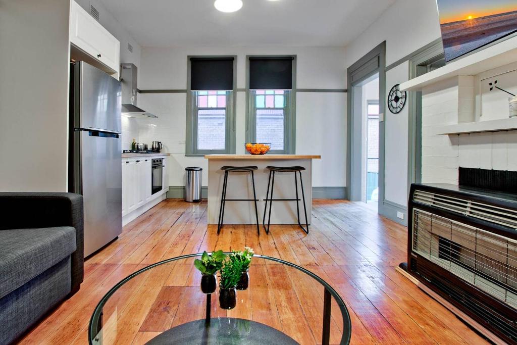 a kitchen and living room with a table in a room at Elements Of Goulburn in Goulburn