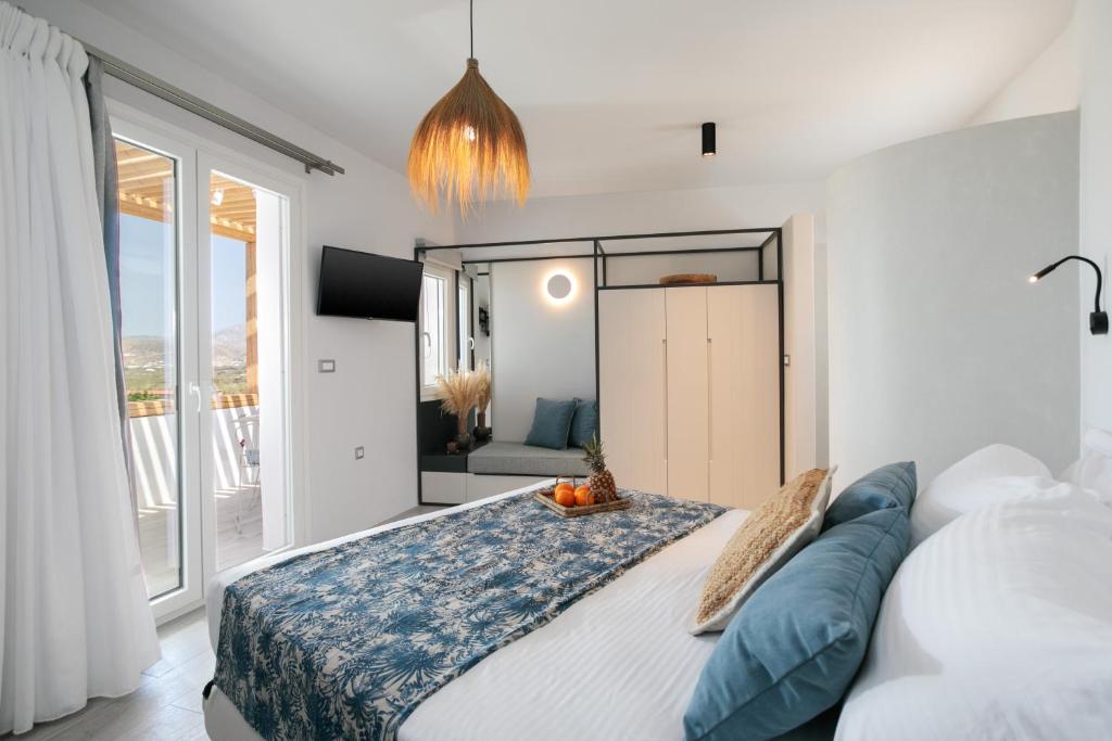 um quarto com uma cama grande e uma janela grande em Sunday Luxury Suites em Agia Anna (Naxos)