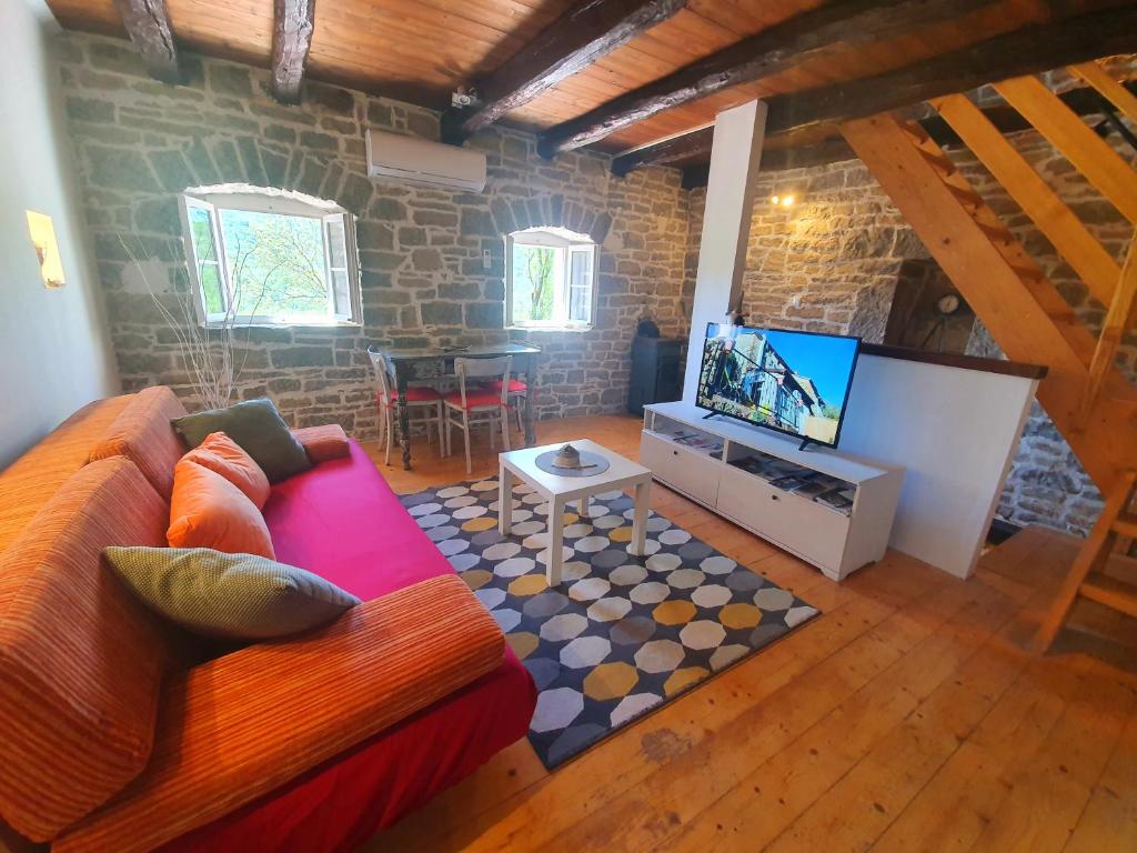 sala de estar con sofá y TV de pantalla plana en Casa Leonarda, old authentic Istrian stone house near Motovun, central Istria en Zamask