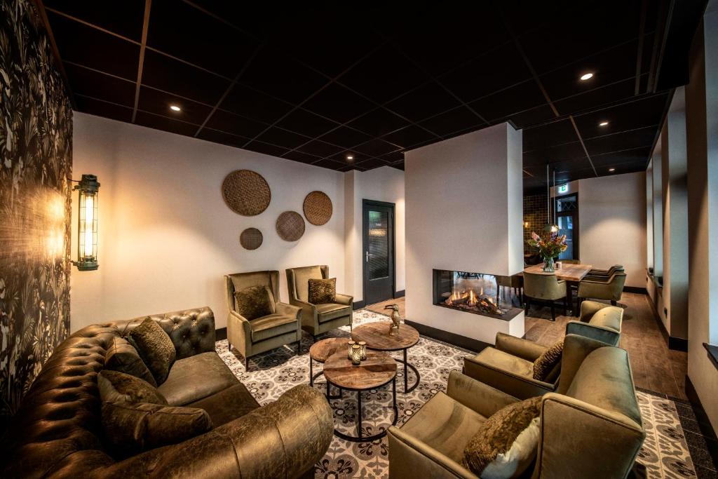 a living room with couches and a fireplace at Grand Café Goejje voorheen Oranje Hotel in Meijel