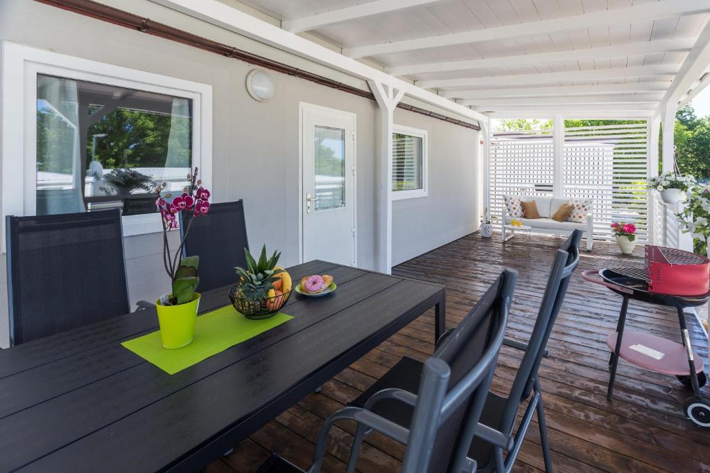 a living room with a wooden table and chairs at Zelena Laguna Mobile Homes in Poreč