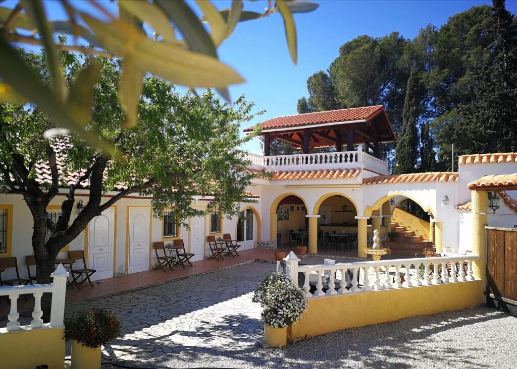 una gran casa blanca con una valla blanca en Finca Bilou, en Aigües