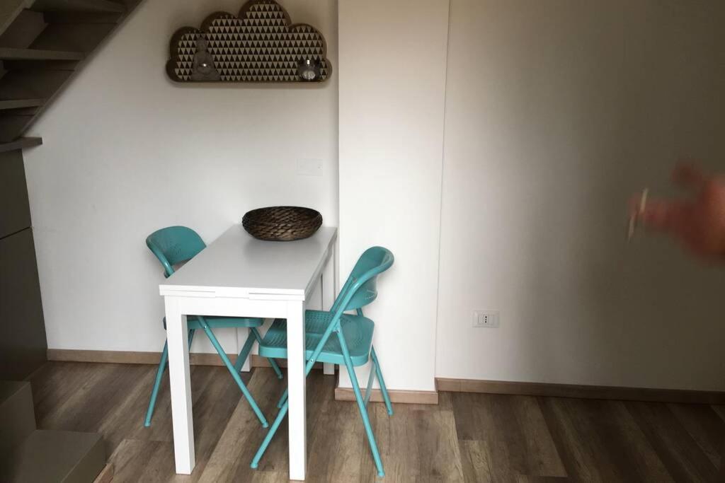 馬里納·迪·比薩的住宿－monolocale con soppalco per coppie，一张白色的桌子和两张蓝色的椅子