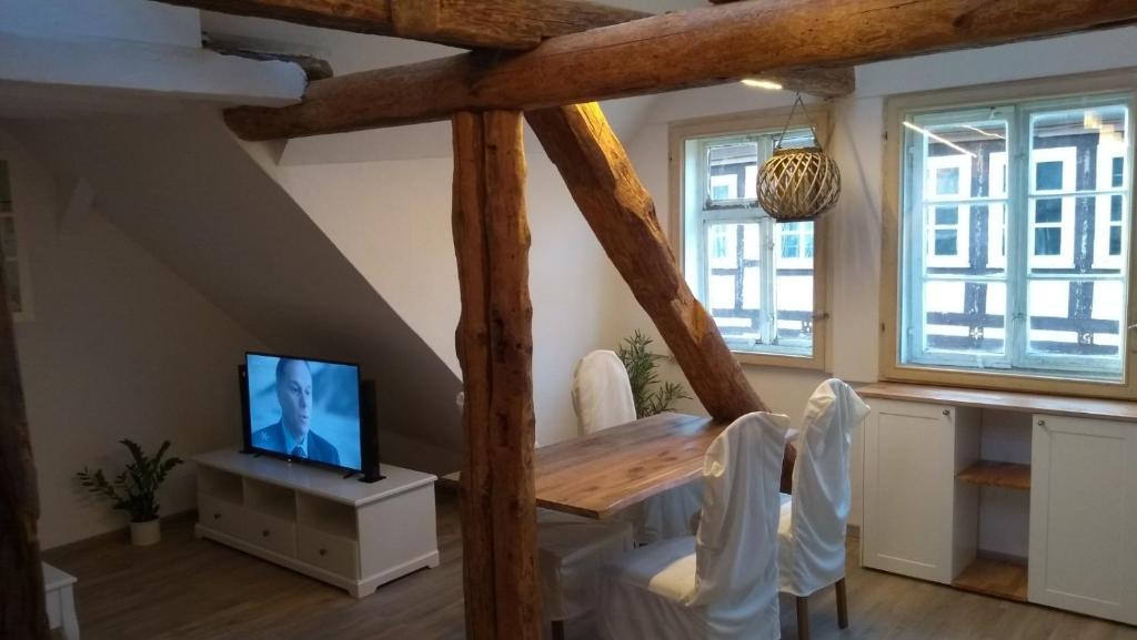 a dining room with a table and a tv at Eulen- & Altstadtnest in Peine