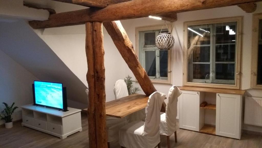 uma sala de jantar com uma mesa de madeira e uma televisão em Eulen- & Altstadtnest em Peine