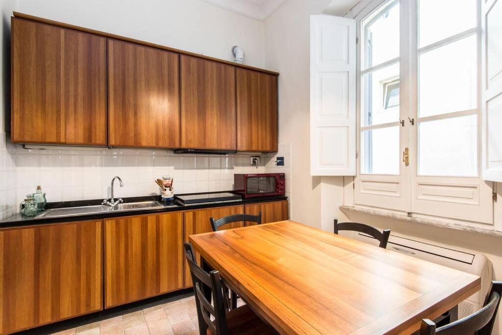 kuchnia z drewnianymi szafkami i drewnianym stołem w obiekcie Vatican Large Comfortable Apartment w Rzymie