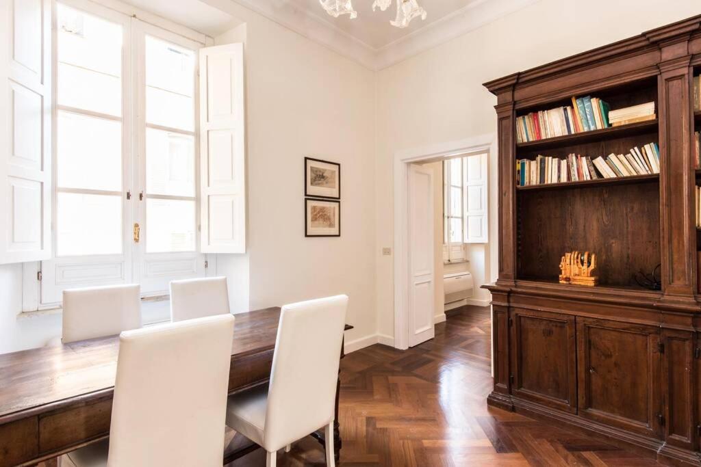 jadalnia z drewnianym stołem i białymi krzesłami w obiekcie Vatican Large Comfortable Apartment w Rzymie