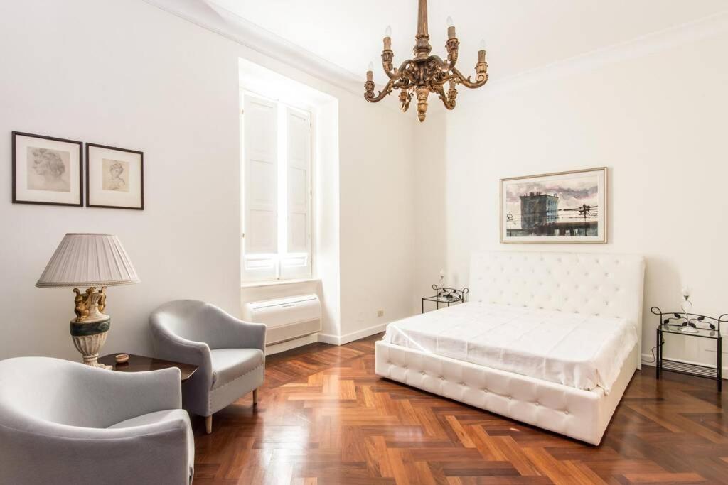sypialnia z łóżkiem, krzesłem i żyrandolem w obiekcie Vatican Large Comfortable Apartment w Rzymie