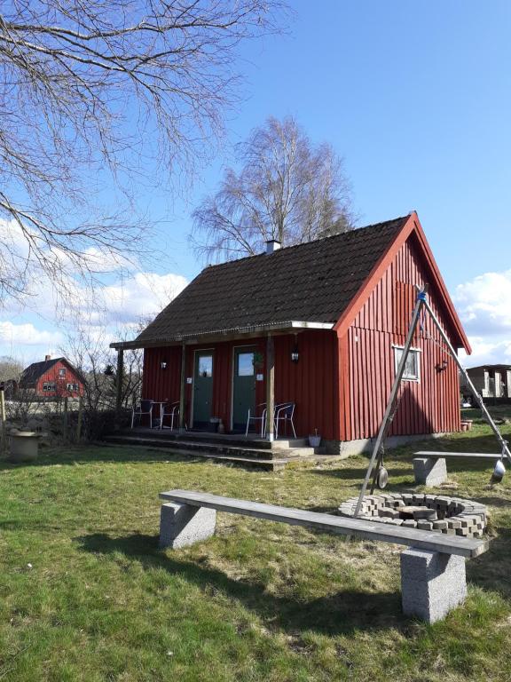 eine rote Scheune mit einem Spielplatz davor in der Unterkunft Knutstorp Ranch in Tyringe