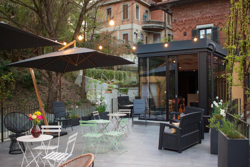 a patio with tables and chairs and an umbrella at VILLA ANNA Suite in Turin