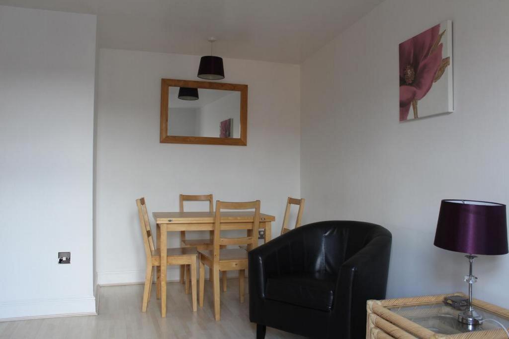 a dining room with a table and a chair and a mirror at Woodsmill Quay Apartments in York