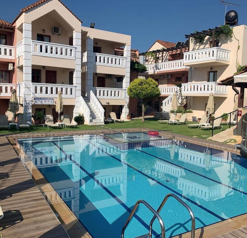 a large swimming pool in front of a building at Kokalas Resort in Georgioupolis
