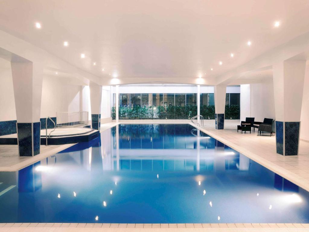 卡地夫的住宿－卡迪夫荷蘭屋Spa美居酒店，大楼内一个蓝色的大型游泳池