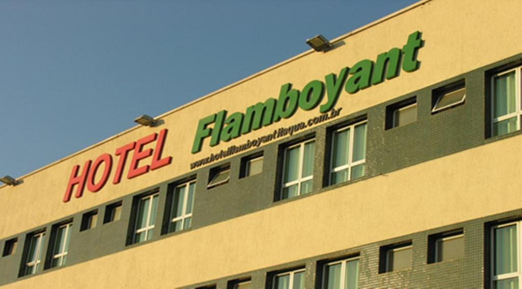 a hotel building with a sign on the side of it at Hotel Flamboyant in Itaquaquecetuba