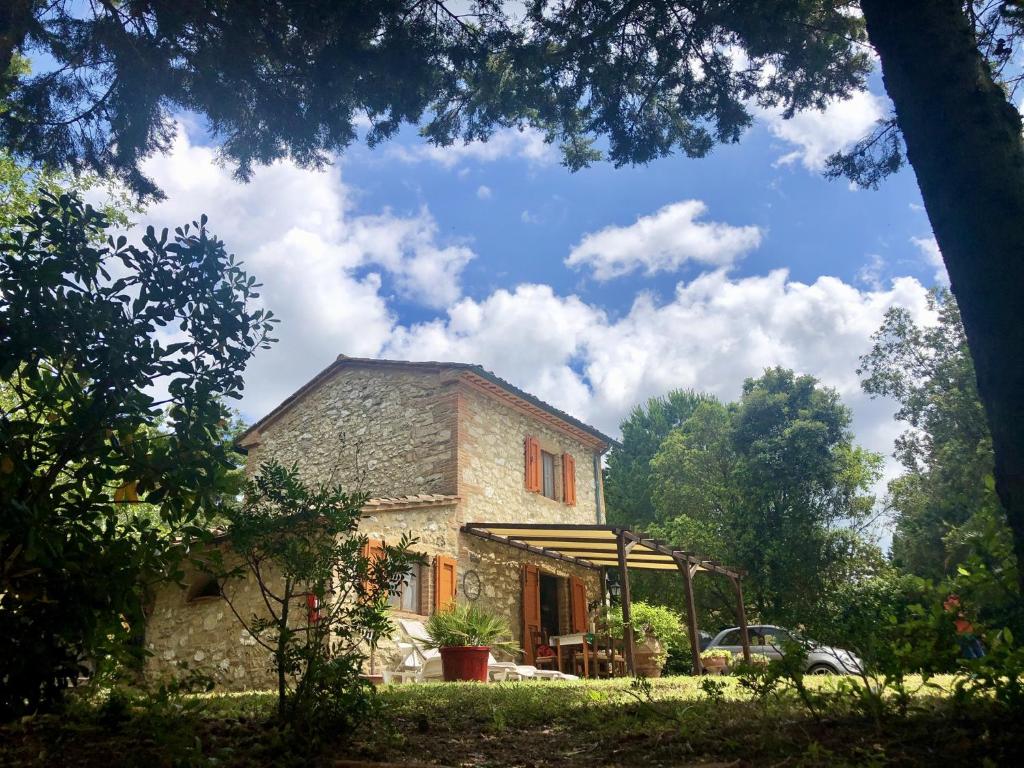 a stone house with a car parked in front of it at Cottage Barbara with aircon, beautiful sea view by ToscanaTour in Casale Marittimo