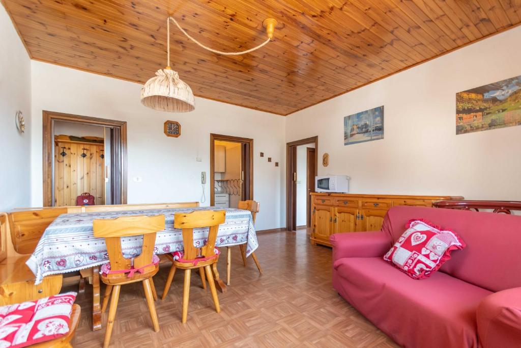 sala de estar con mesa y sofá en Casa Carnevali en Pozza di Fassa